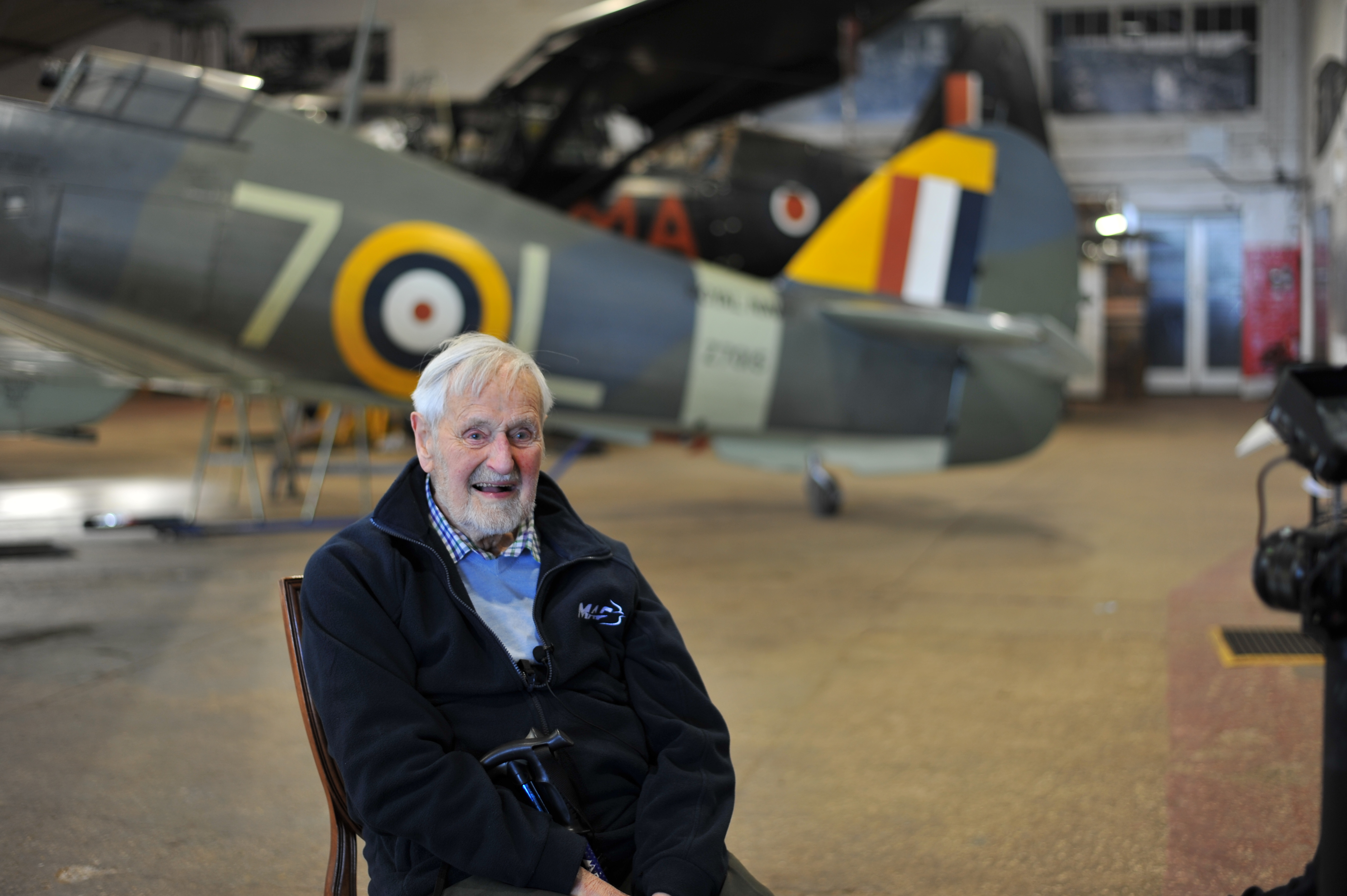 Jack inside hangar with Spitfires.